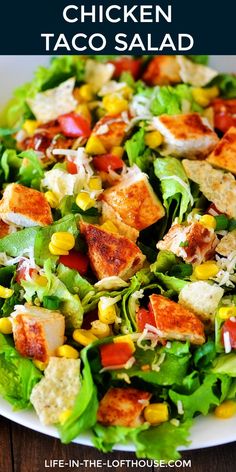 chicken taco salad with lettuce, corn and tomatoes in a white bowl