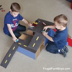 two young boys playing with toys on the floor