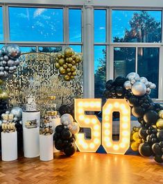 an image of a 50th birthday party with balloons and lights on the floor in front of it