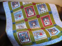 a quilted christmas scene is displayed on a couch