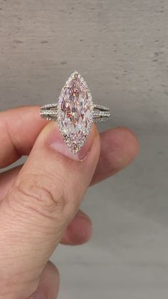 a person holding an oval shaped diamond in their hand