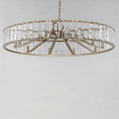 a chandelier hanging from the ceiling with clear glass and metal rods on it