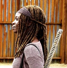 a woman with dreadlocks holding a baseball bat