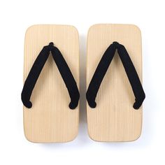 pair of wooden sandals with black straps on white background