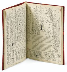 an open book with writing on it and red trim around the page, which is covered in black ink