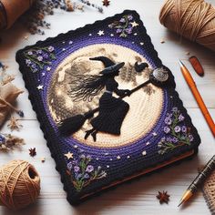 a crocheted halloween scene with a witch on the moon