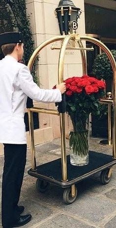 a man is placing flowers in a vase on a cart