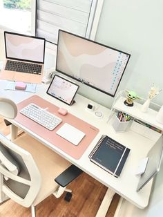 a desk with two laptops and a desktop computer on it, all in different colors