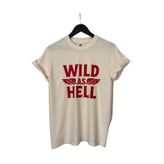 This faded distressed Wild as Hell shirt is perfect to dress up or wear casual! Wild as Hell Shirt, Vintage Graphic Tops for Women Grunge Shirt With Text Print For Summer, Grunge Summer Shirt With Text Print, Summer Grunge Shirt With Text Print, Grunge Style Text Print Shirt For Summer, Spring Streetwear Faded Tops, Spring Grunge Letter Print Shirt, Trendy Distressed Faded Tops, Trendy Faded Distressed Tops, Distressed Graphic Tee Shirt In Relaxed Fit