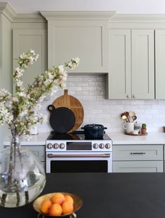 a kitchen with an oven, stove and fruit bowl on the counter top in front of it