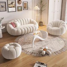 a living room filled with white furniture on top of a hard wood floor