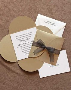 the wedding stationery is laid out on top of each other, with a bow