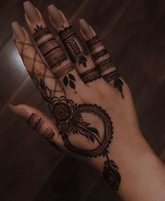 a woman's hand with henna tattoos on it