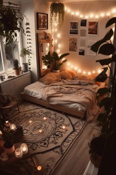 a bedroom with lots of plants and lights on the wall above the bed is lit up by candles