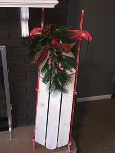 a wooden sled decorated with holly and pine cones