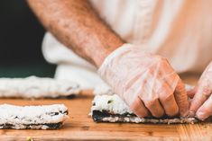 a person with gloves on their hands is making sushi