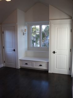 an empty room with white doors and windows