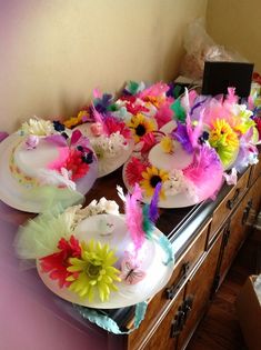 plates with flowers and feathers on them are sitting on a table in front of a dresser