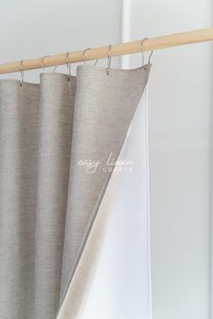 an open curtain with the word easy clean printed on it hanging from a wooden rod