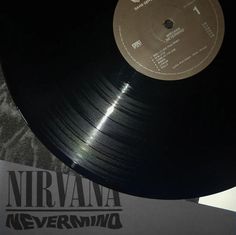 an old record is sitting on top of a paper sheet with the word nirvana in it