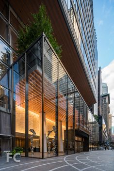 an empty street in front of a tall building with lots of glass and wood on it