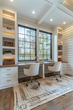 a home office with two chairs and a rug in front of the window, along with built - in shelving