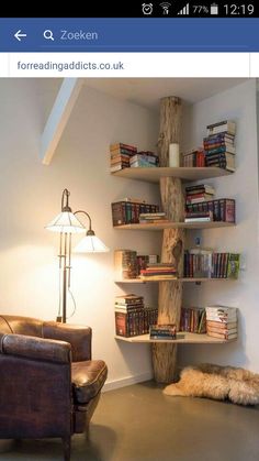 a living room with a leather chair and bookshelf in the corner next to a lamp