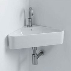 a white sink mounted to the side of a wall next to a faucet