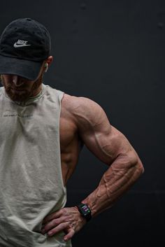 a man standing with his back to the camera, wearing a hat and holding his hands on his hips