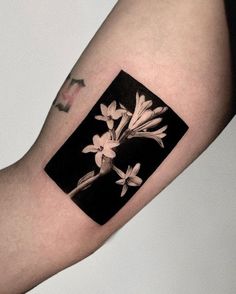 a black and white photo with flowers on it's arm, in the shape of a square