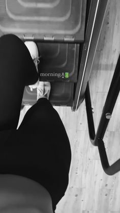 a person in black pants standing next to a stove top oven with the word morning written on it