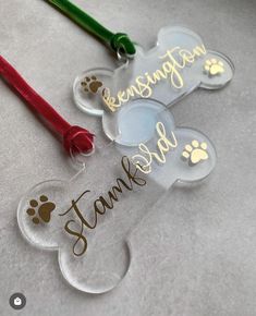 two clear acrylic ornament with dog paw prints and name on them