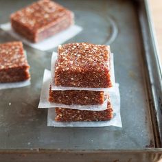 three pieces of brownie sitting on top of each other next to some wax paper