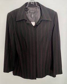 This, new with tags, Lane Bryant black blazer jacket features pink pinstripes, light shoulder pads, large buttons on the sleeves, and hidden buttons down the front. The relaxed fit and lightweight material make it perfect for any occasion…pair it with a shimmery top for the holidays! In a women’s size 14, this blazer is a great wardrobe basic! Please see photos for actual measurements.