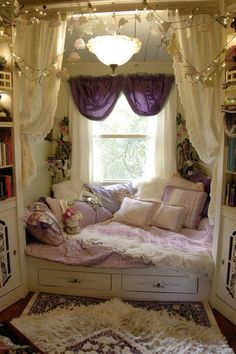 a room with a bed, bookshelf and window covered in purple drapes