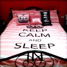 a bed with pink and white comforter, pillows and pillowcases on it