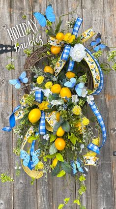 a wreath with blue and yellow flowers on top of a wooden floor next to a fence