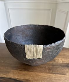 a black bowl sitting on top of a wooden table