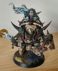 a painted warhammer with two swords and skulls on his head, standing on a wooden table