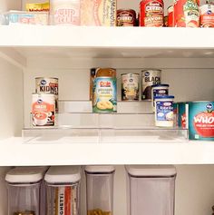 an open refrigerator filled with lots of food and drink cans next to other items on shelves