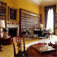 a living room filled with furniture and a chess board in front of a fire place