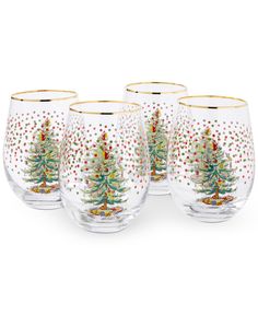 four glasses with christmas trees painted on the side and gold rims, all in different colors