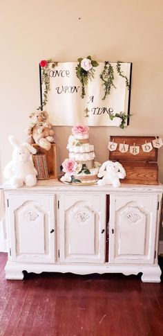 there is a white buffet with teddy bears on the top and flowers on the bottom