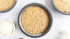 three pans filled with cake batter next to other ingredients