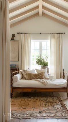 a bed sitting in the middle of a bedroom next to a window with white curtains