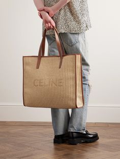 CELINE HOMME's tote is woven from raffia and features the label's moniker across the front. It's reinforced with leather trims and has a generous canvas-lined interior that can easily fit your essentials for a long commute or day at the beach. Luxury Rectangular Straw Bag For Shopping, Luxury Rectangular Straw Shopping Bag, Designer Beige Rectangular Straw Bag, Luxury Woven Straw Shopping Bag, Designer Woven Straw Shopping Bag, Designer Beige Handwoven Bag, Designer Handwoven Beige Bag, Designer Straw Bag With Woven Leather For Shopping, Designer Straw Bag With Leather Handles For Shopping