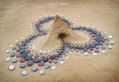 a sand castle made out of rocks and pebbles with a spiral design on it's side