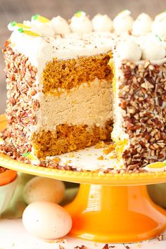 a carrot cake with white frosting and sprinkles on a yellow plate