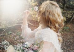 a woman holding a flower in her right hand