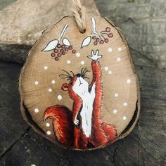 a wooden ornament with an image of a red squirrel on it's back